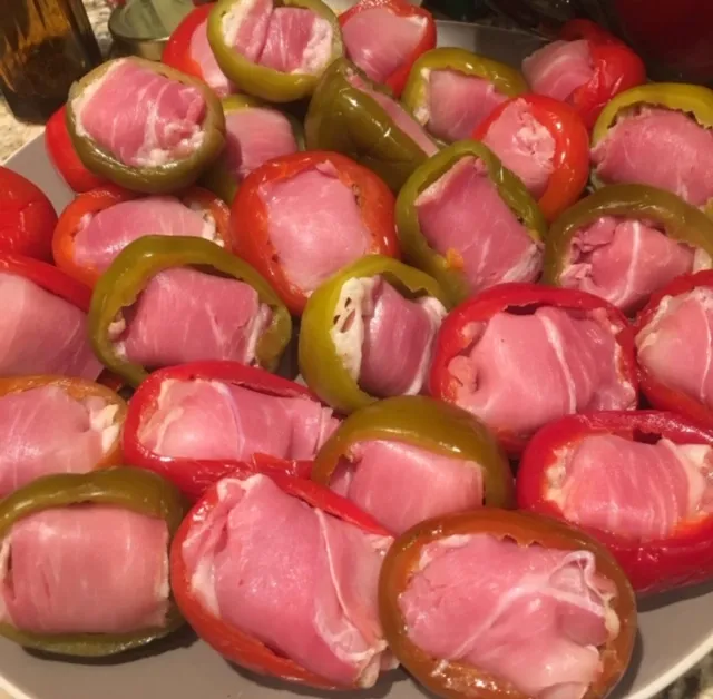 Red and green cherry peppers stuffed and arranged on a platter